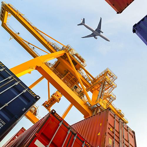 container cargo freight ship with working crane loading bridge shipyard logistic